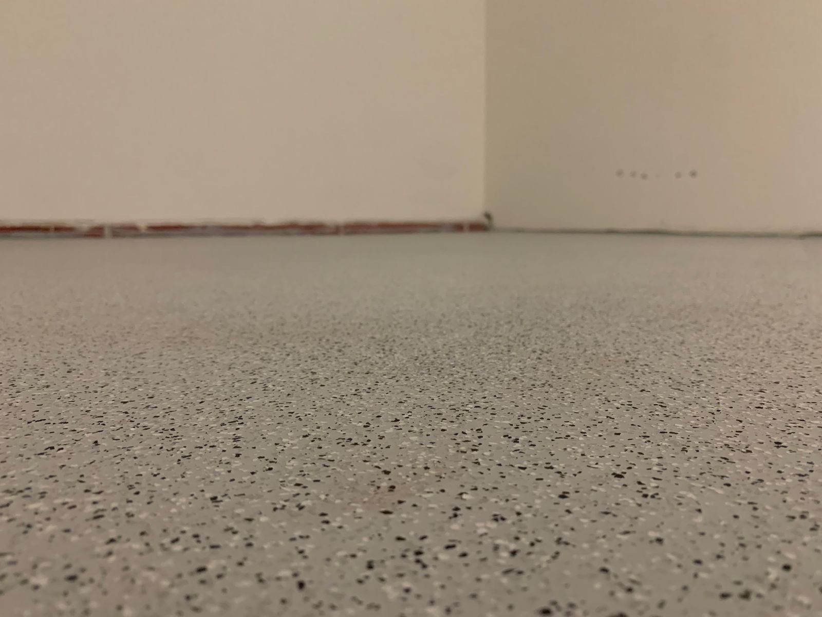 Detail einer hellen Bodenbeschichtung mit Chips